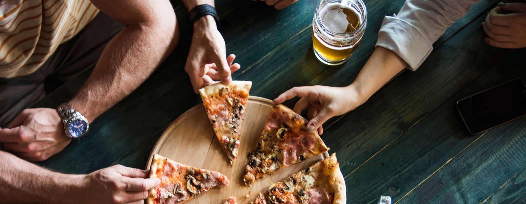 a group of people eating pizza