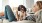 woman lies on a couch and pets her dog